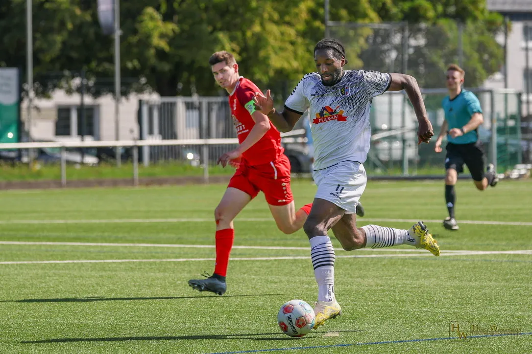 Brice Braquin sprinting with the ball for SVE Mendig, a defender chasing